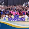 Large group of Athletes at Westcliff University posing for a photo. In the front there is a sign that reads go warrioers.